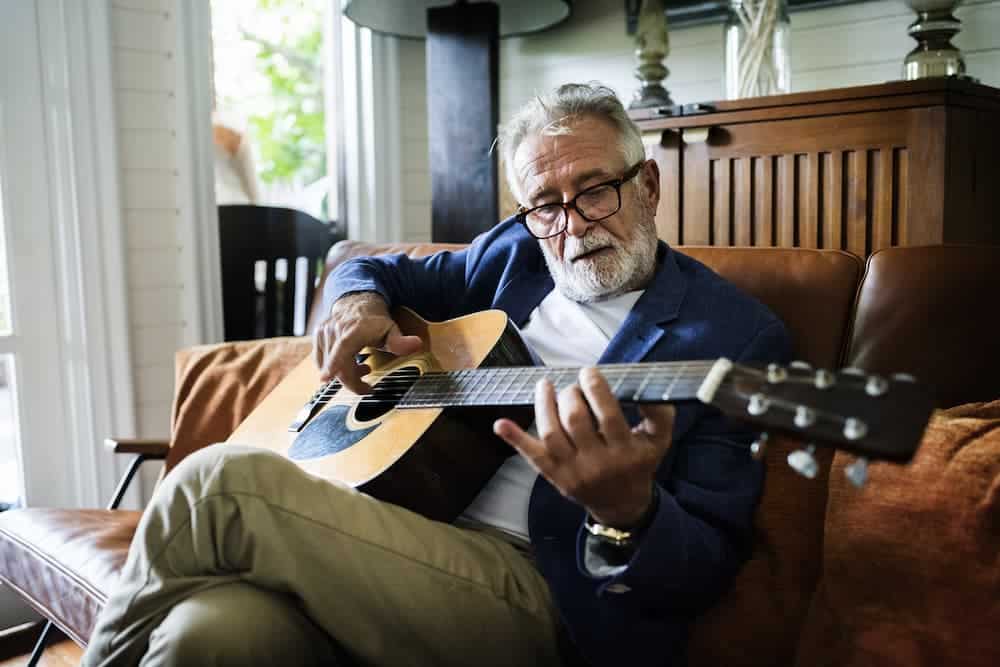 senior playing a guitar